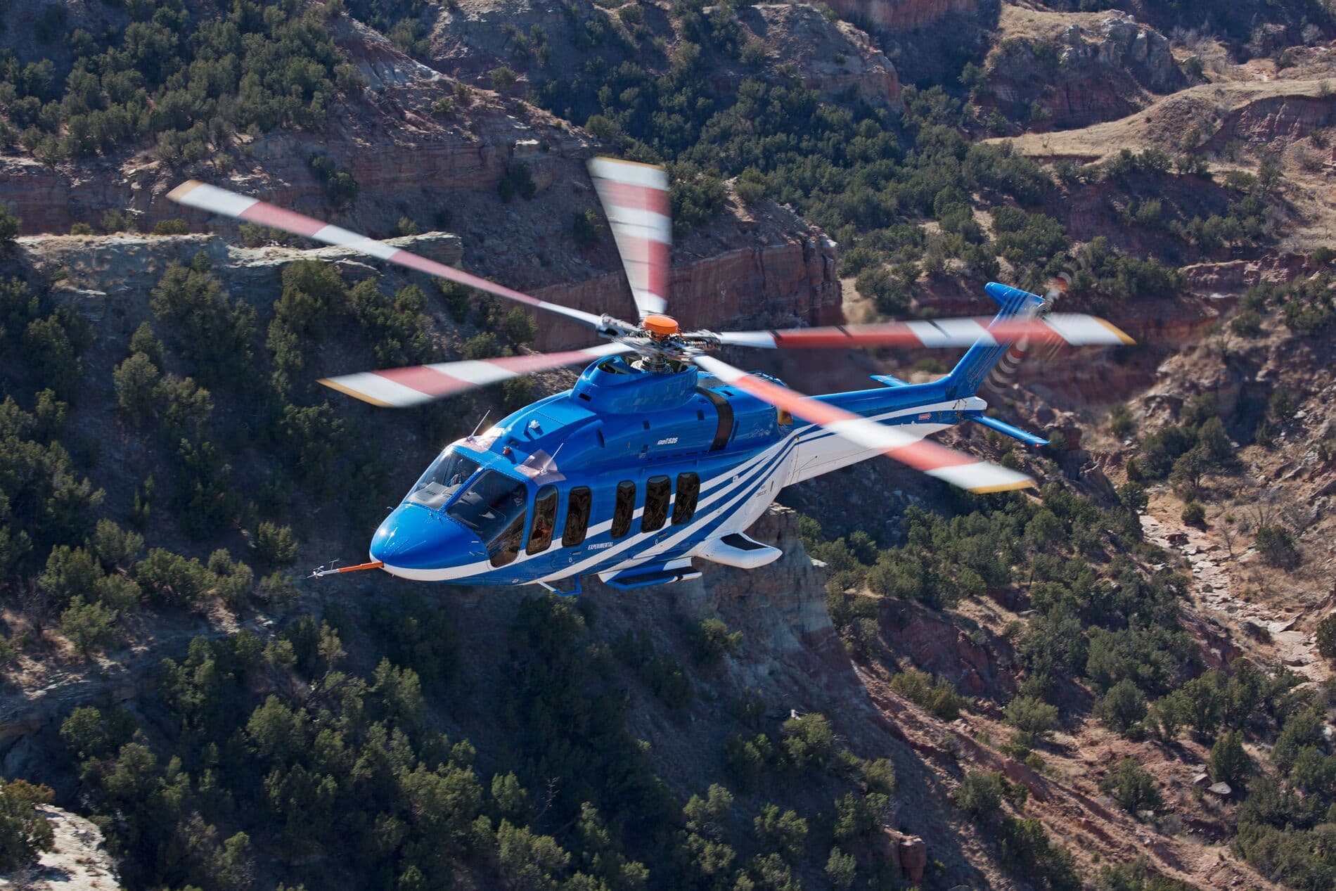 Bell 525 In Flight Over Green Desert Mountains